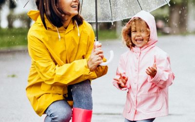 Mother with daughter walking in the rain under the umbrella Mother with daughter walking in the rain under the umbrella