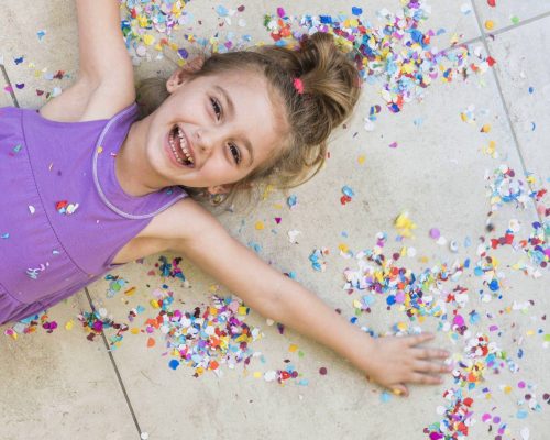 overhead-view-happy-cute-girl-lying-with-confetti-floor_2