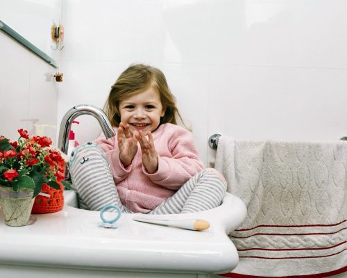 portrait-happy-girl-sitting-bathroom-sink_2